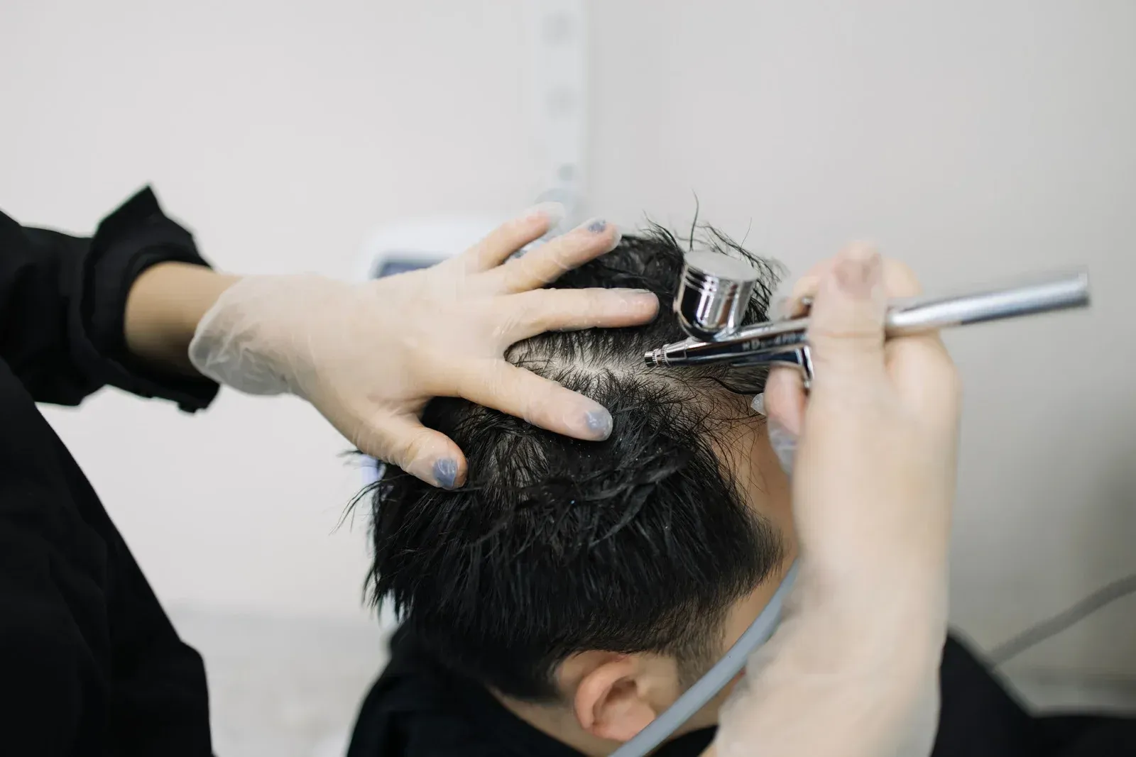 Doctor in white coat with stethoscope, taking notes on a clipboard while consulting with a patient.