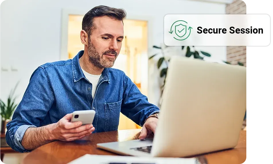Man using laptop and phone, in a home setting,