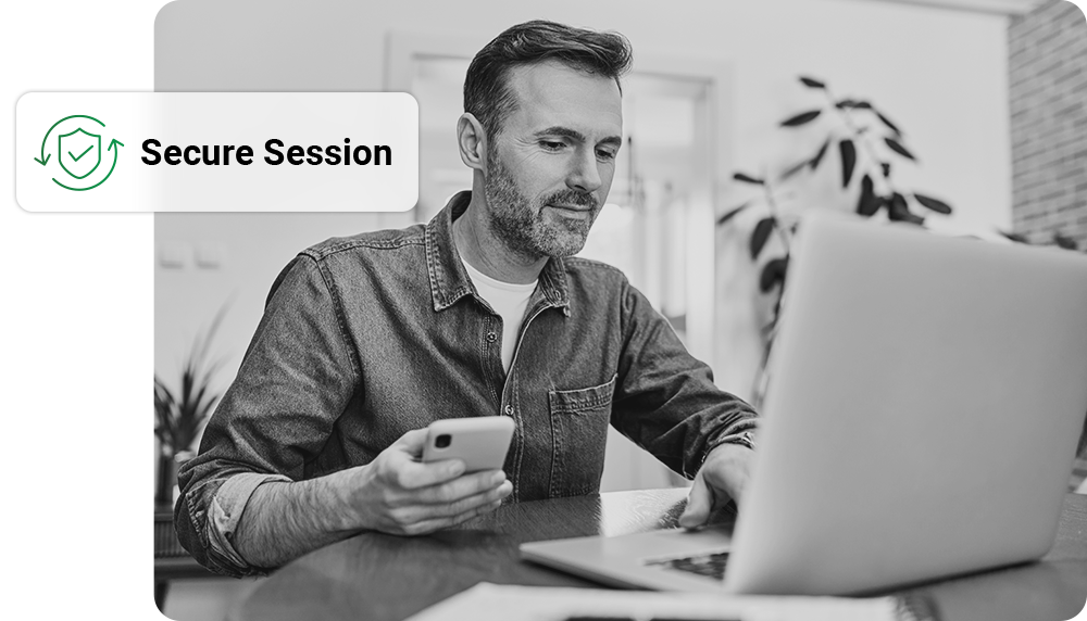 Man using laptop and phone in home setting, 