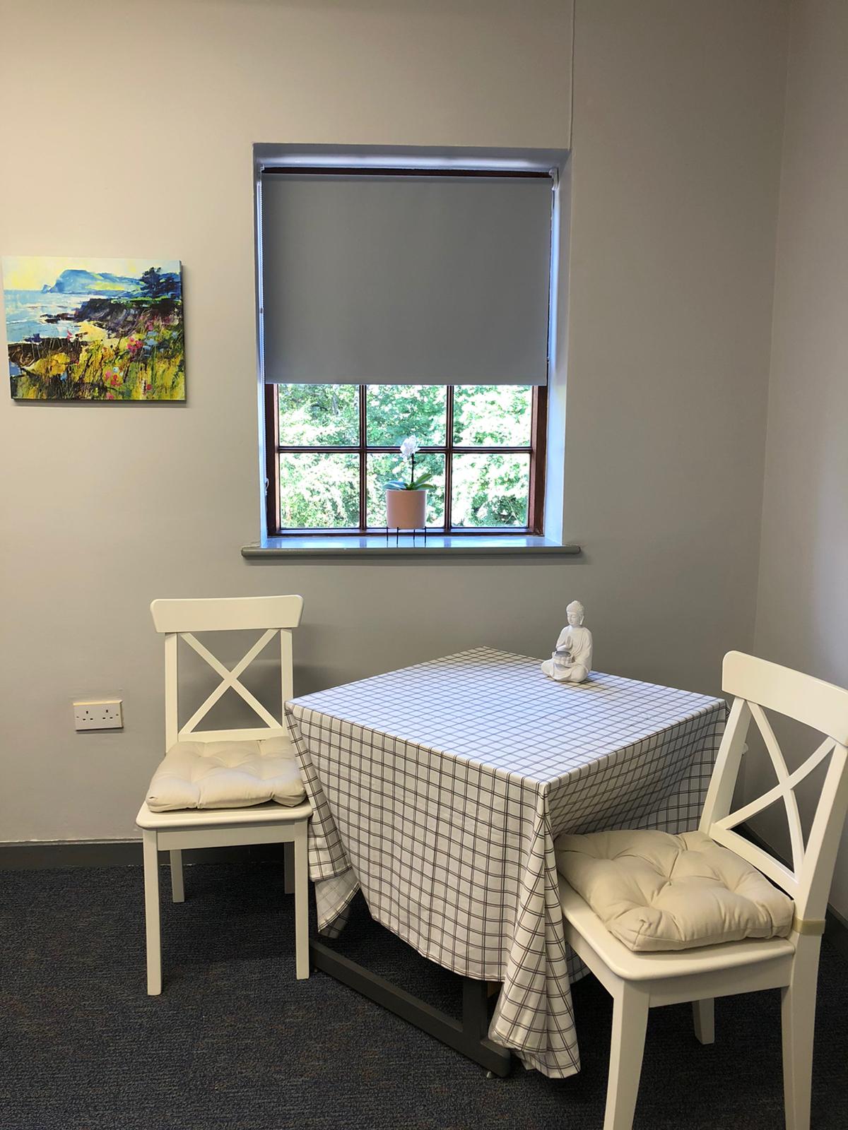 A room with a table and chairs in front of a window. Dramatherapy Ireland