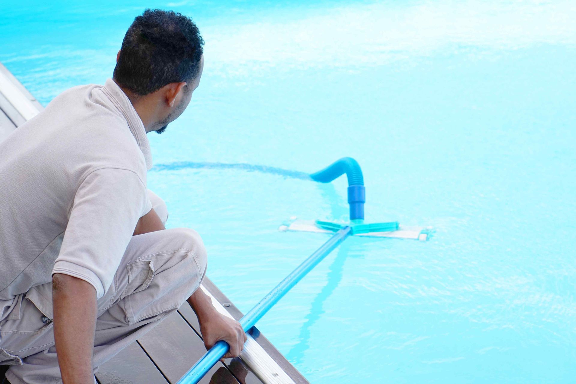 A worker is giving a pool cleaning service