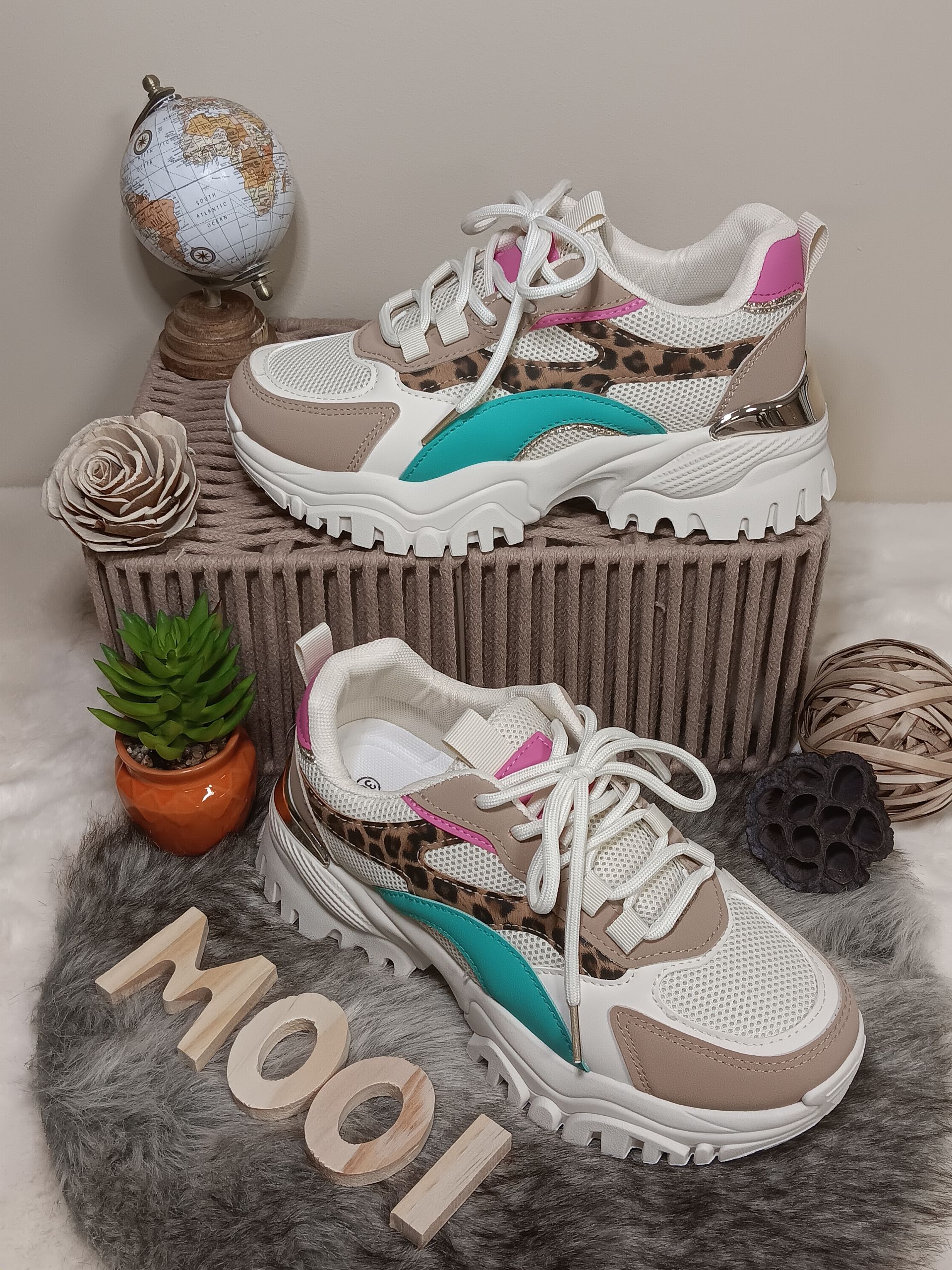 Een paar sneakers liggen bovenop een mand.