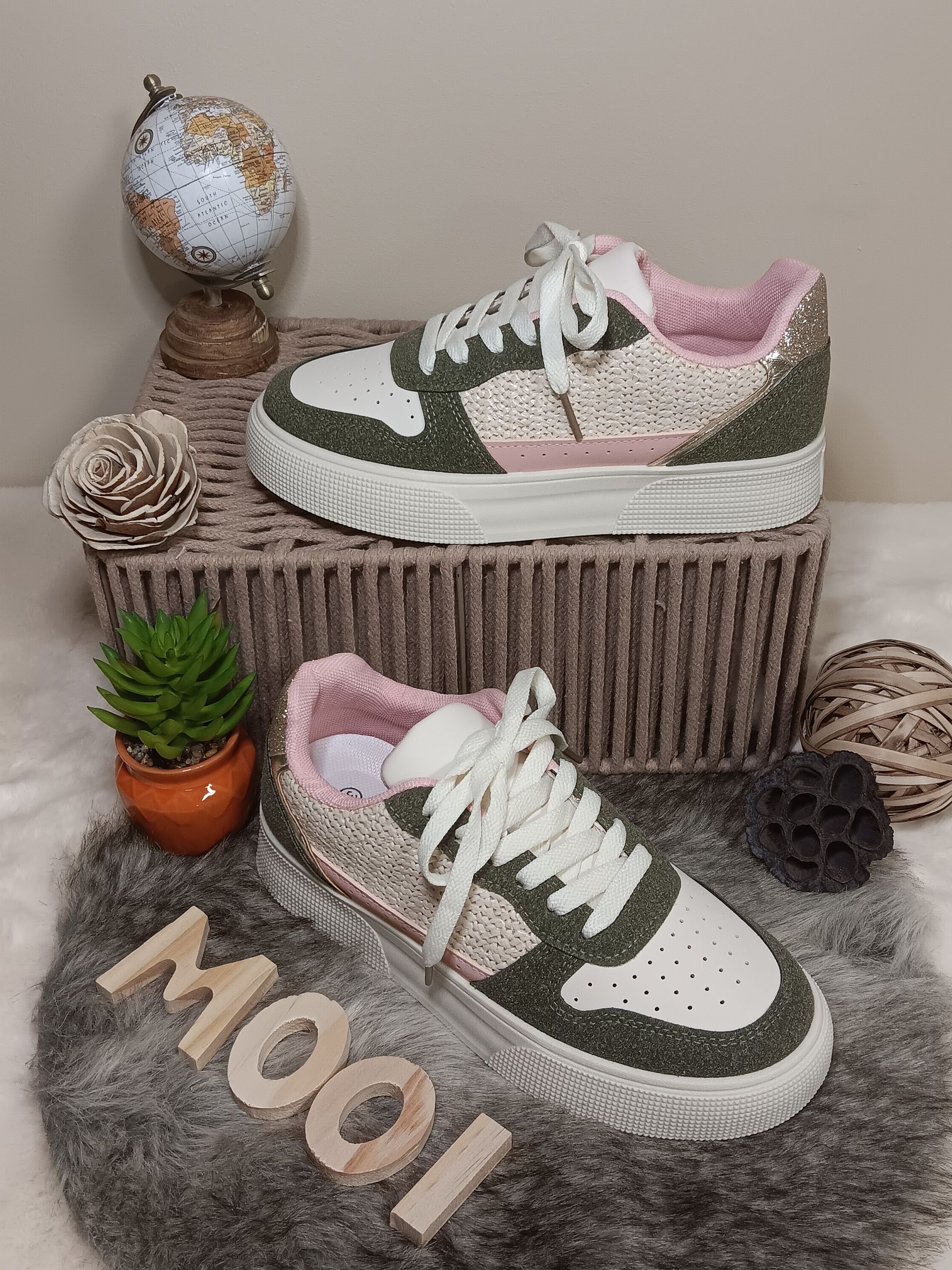 Een paar sneakers liggen op een kleed.