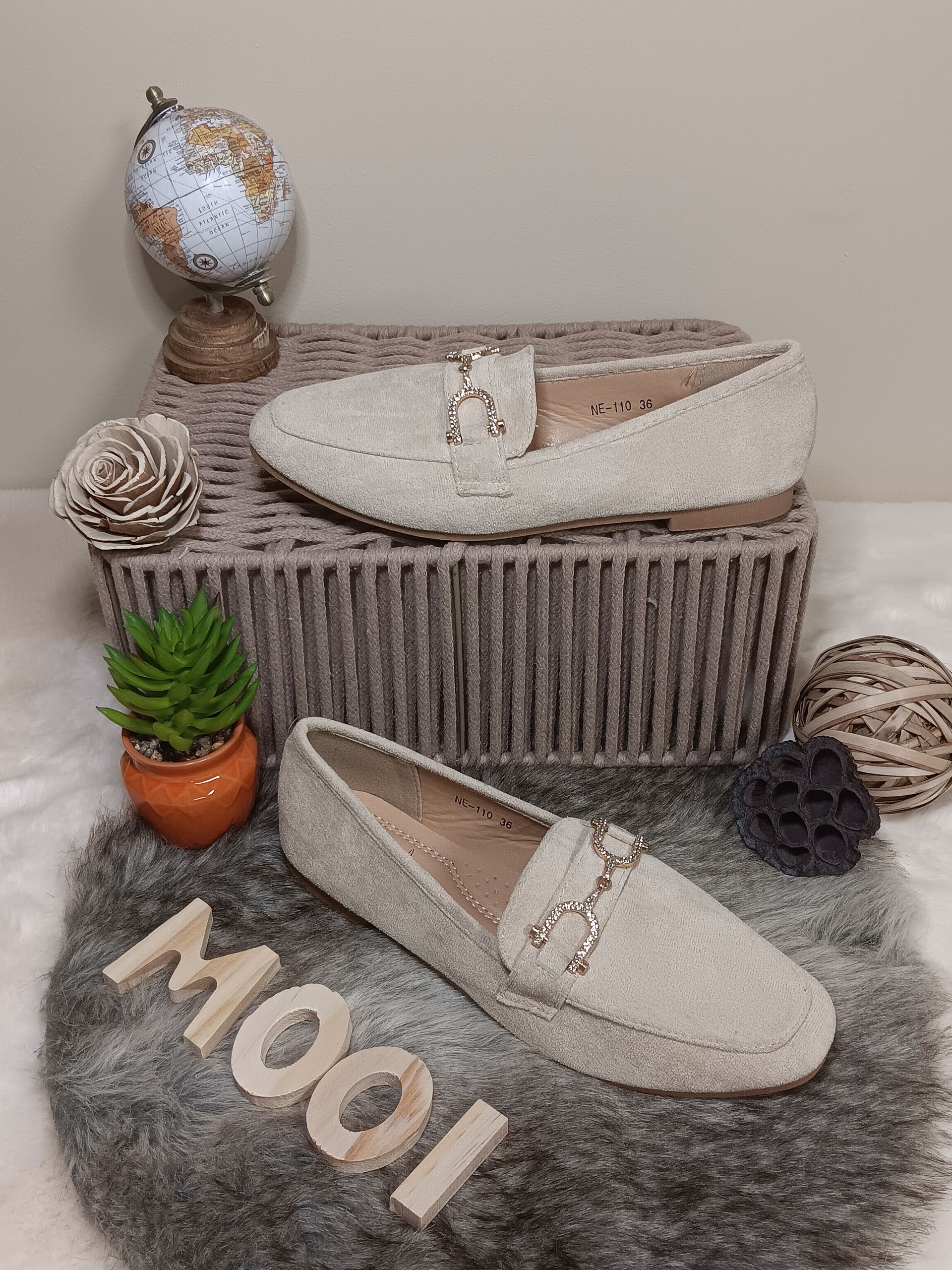 Een paar witte loafers op een kleed.