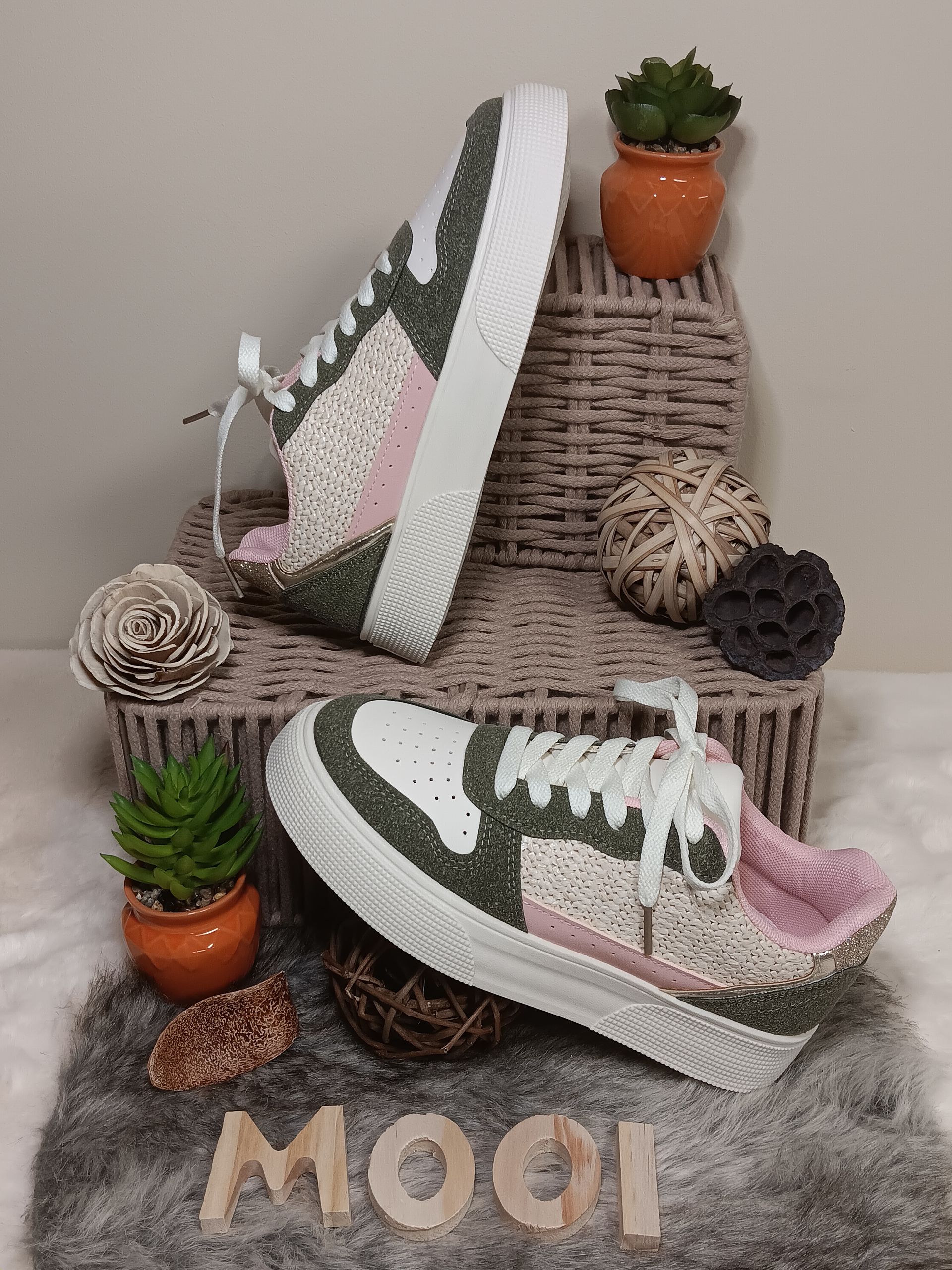 Een paar sneakers liggen op een kleed.