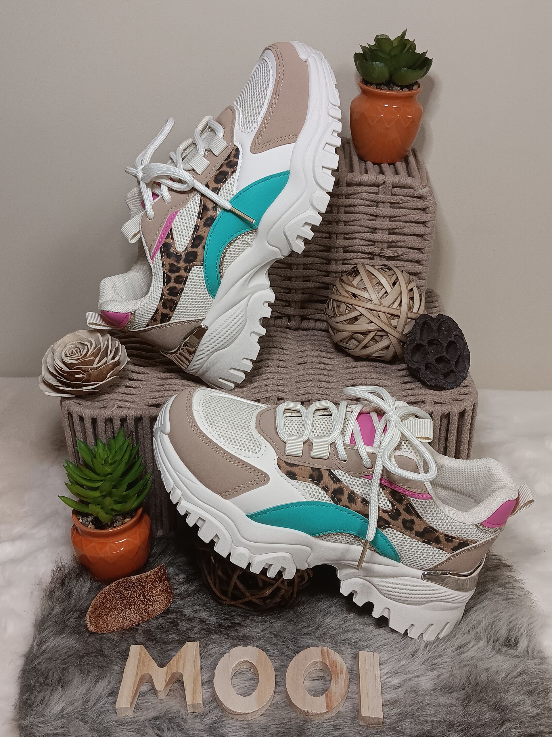 Een paar sneakers liggen bovenop een mand.