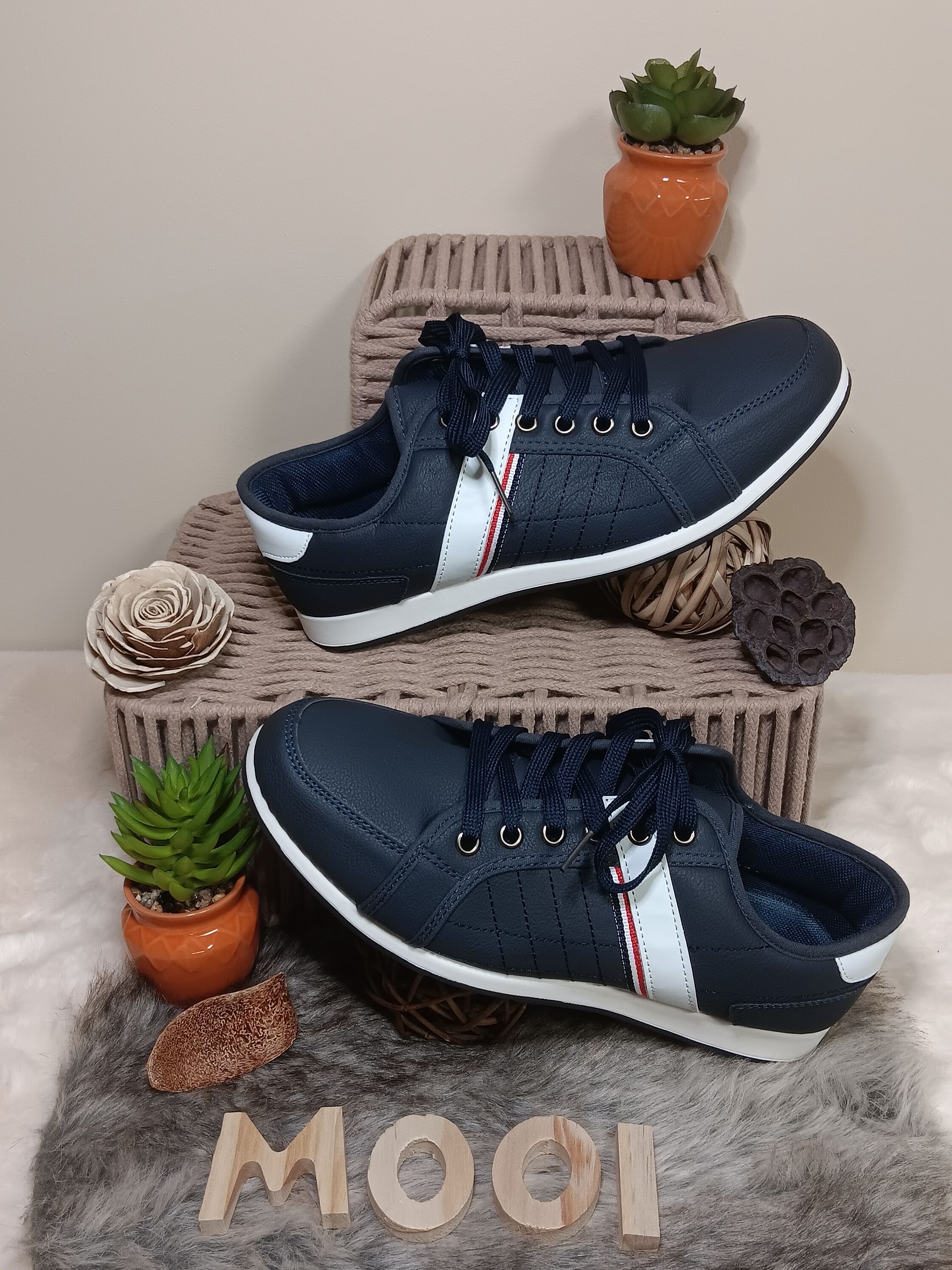 Een paar blauwe sneakers liggen bovenop een rieten mand.