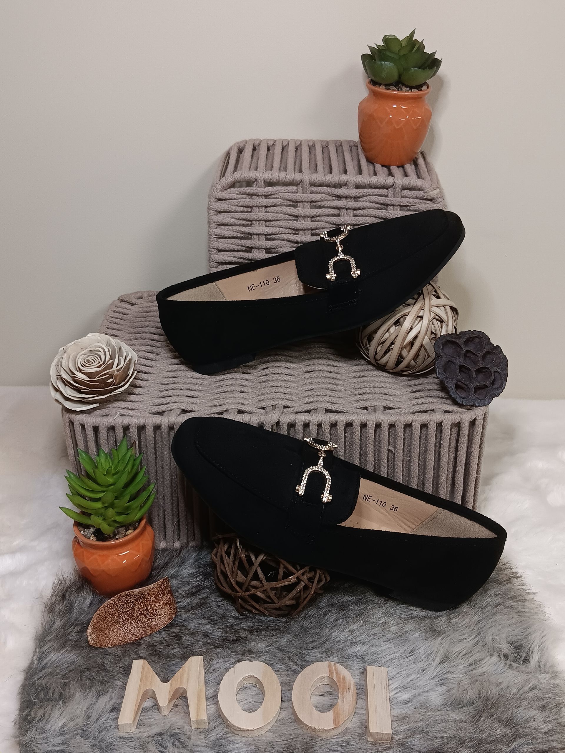 Een paar zwarte loafers staan bovenop een wereldbol.