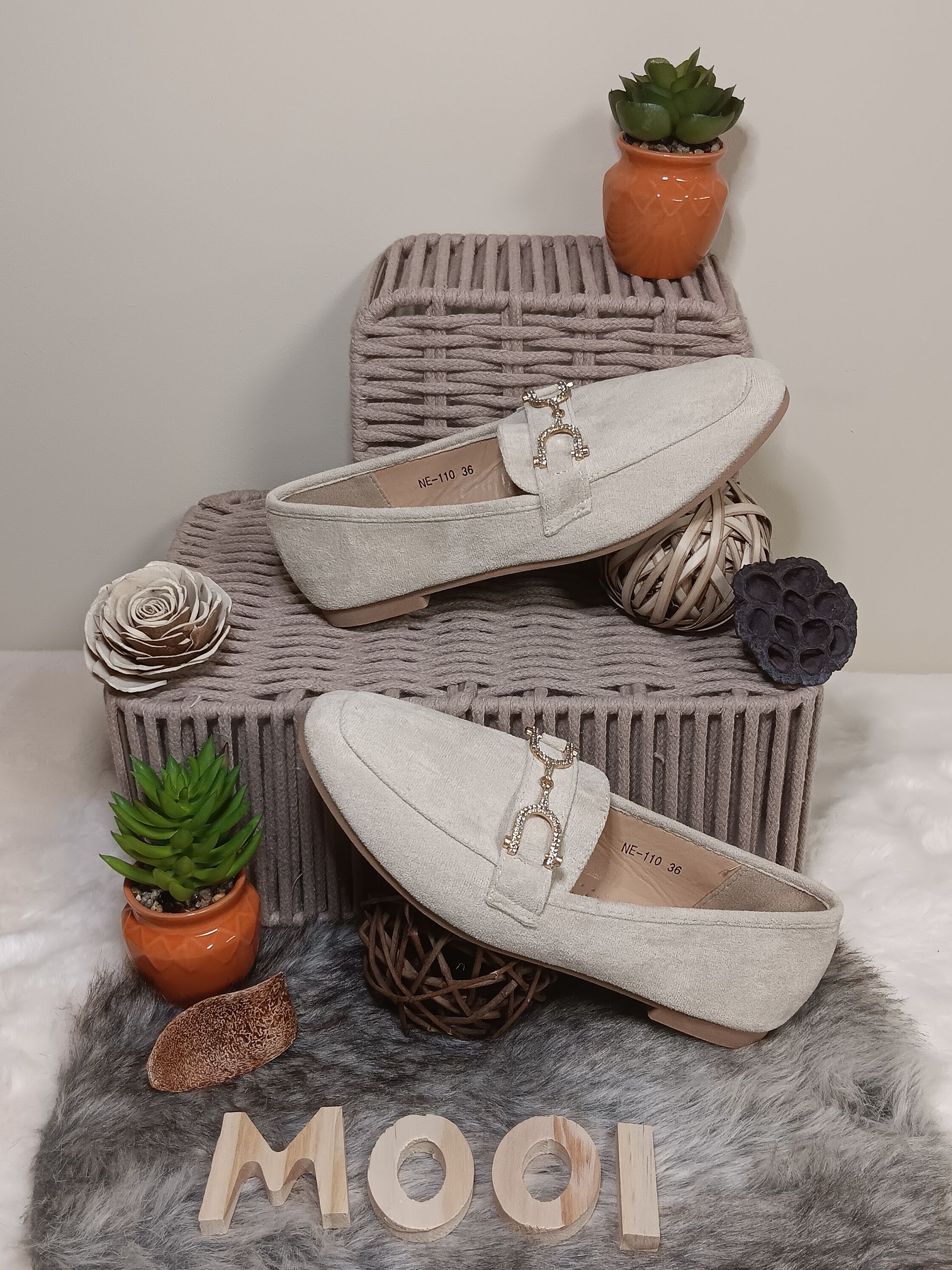 Een paar witte loafers op een kleed.