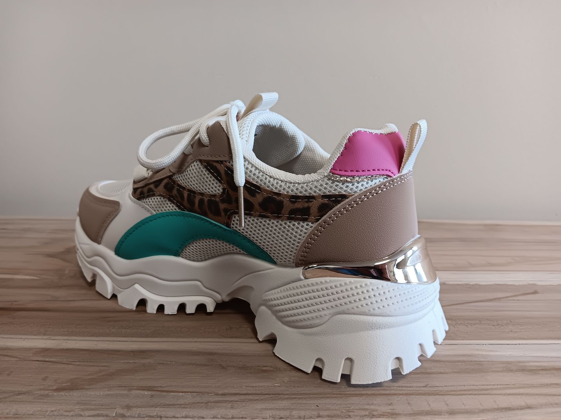 Een paar sneakers staan ​​op een houten tafel.