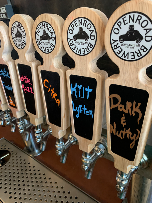 A row of wooden beer taps from openroad brewery