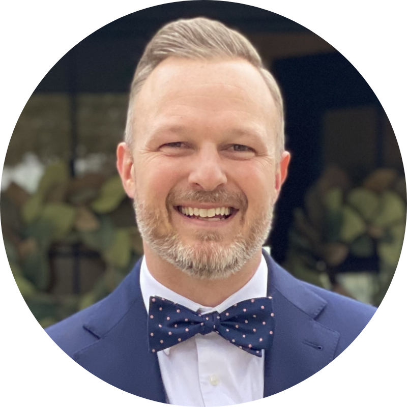 A man in a suit and bow tie smiles for the camera