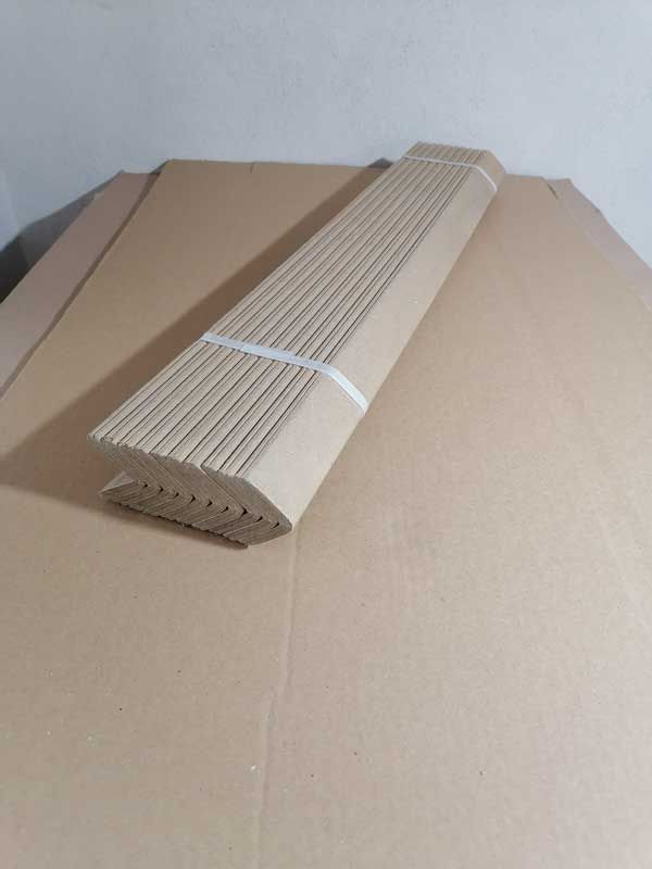 Hay un trozo largo de cartón encima de una caja de cartón.