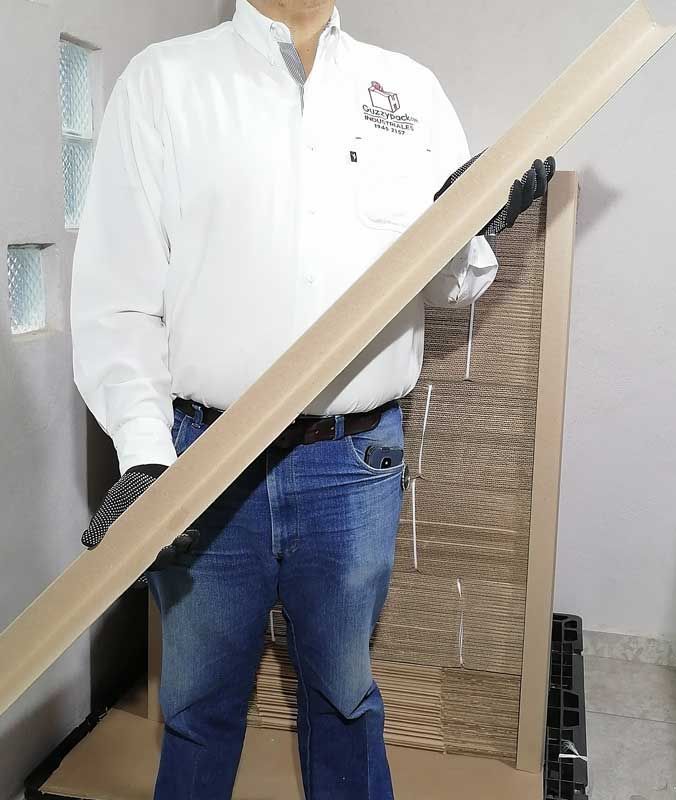 Un hombre con una camisa blanca sostiene un largo trozo de madera