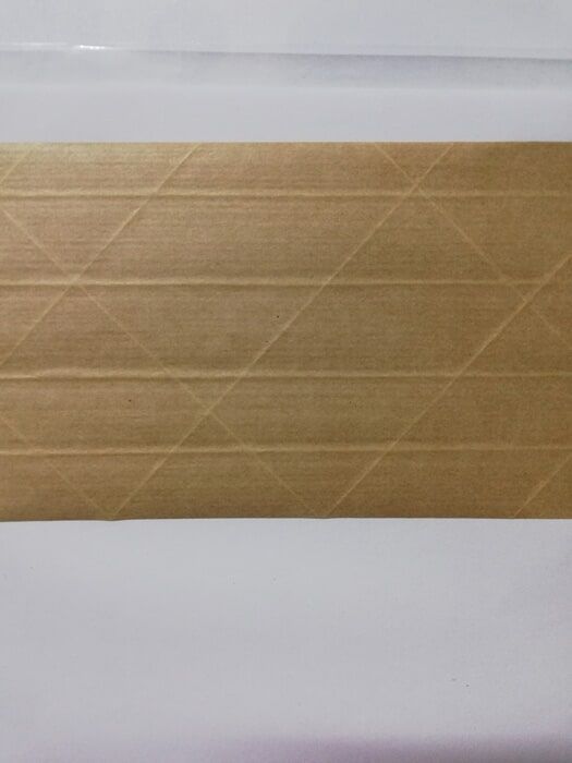 Un primer plano de un trozo de papel marrón sobre una superficie blanca.
