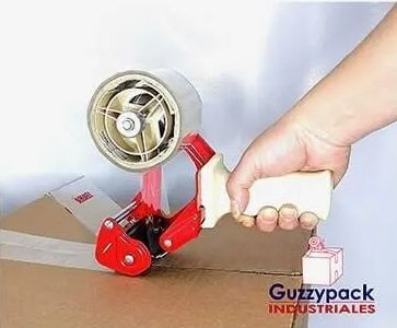 Una persona está usando un dispensador de cinta para pegar una caja.
