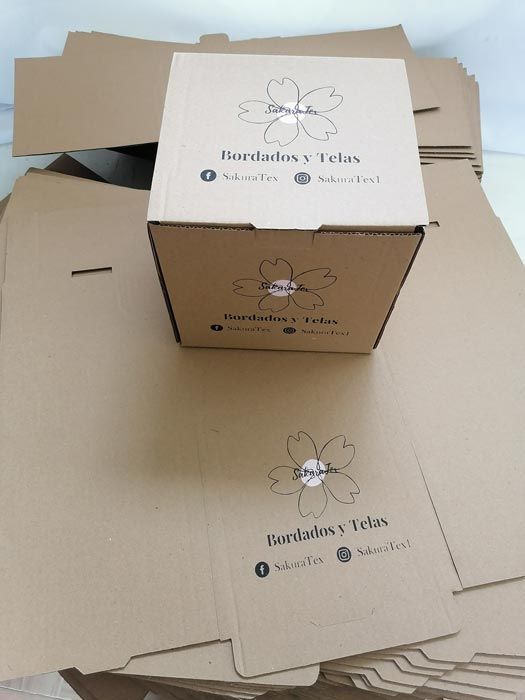 Una caja de cartón con la palabra bordados y telas