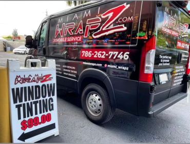A van with a sign that says window tinting on it