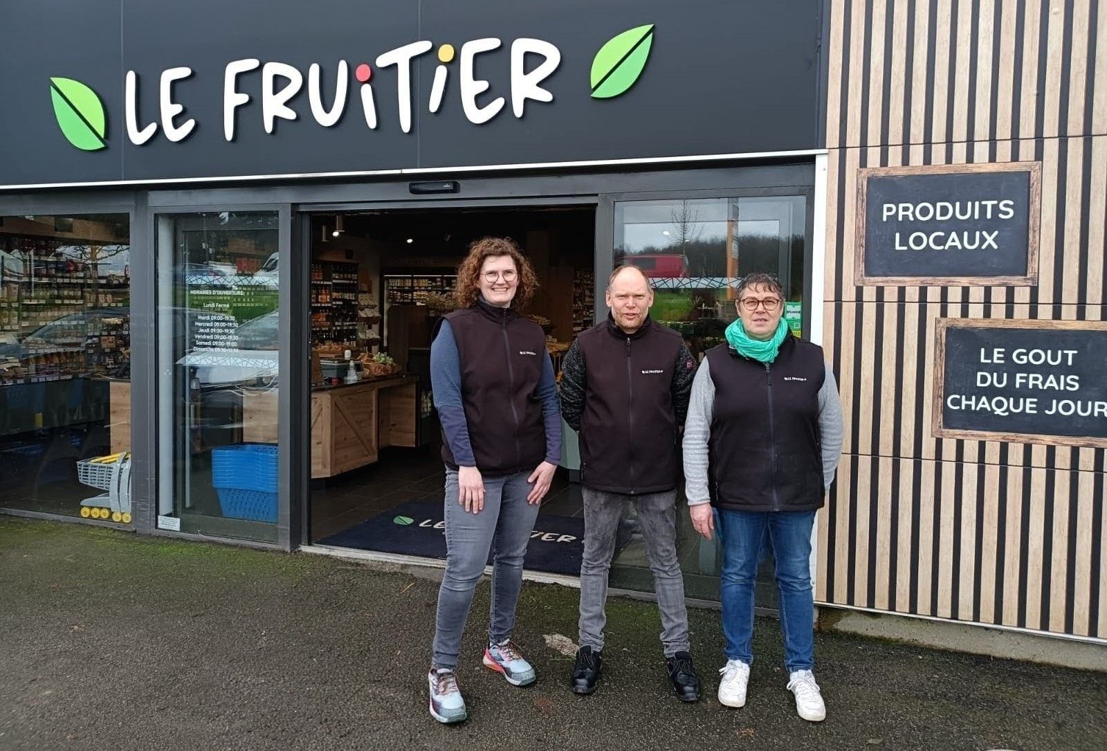 Présentoir de produits frais comprenant des concombres, des avocats, du fenouil, des radis et d'autres légumes.