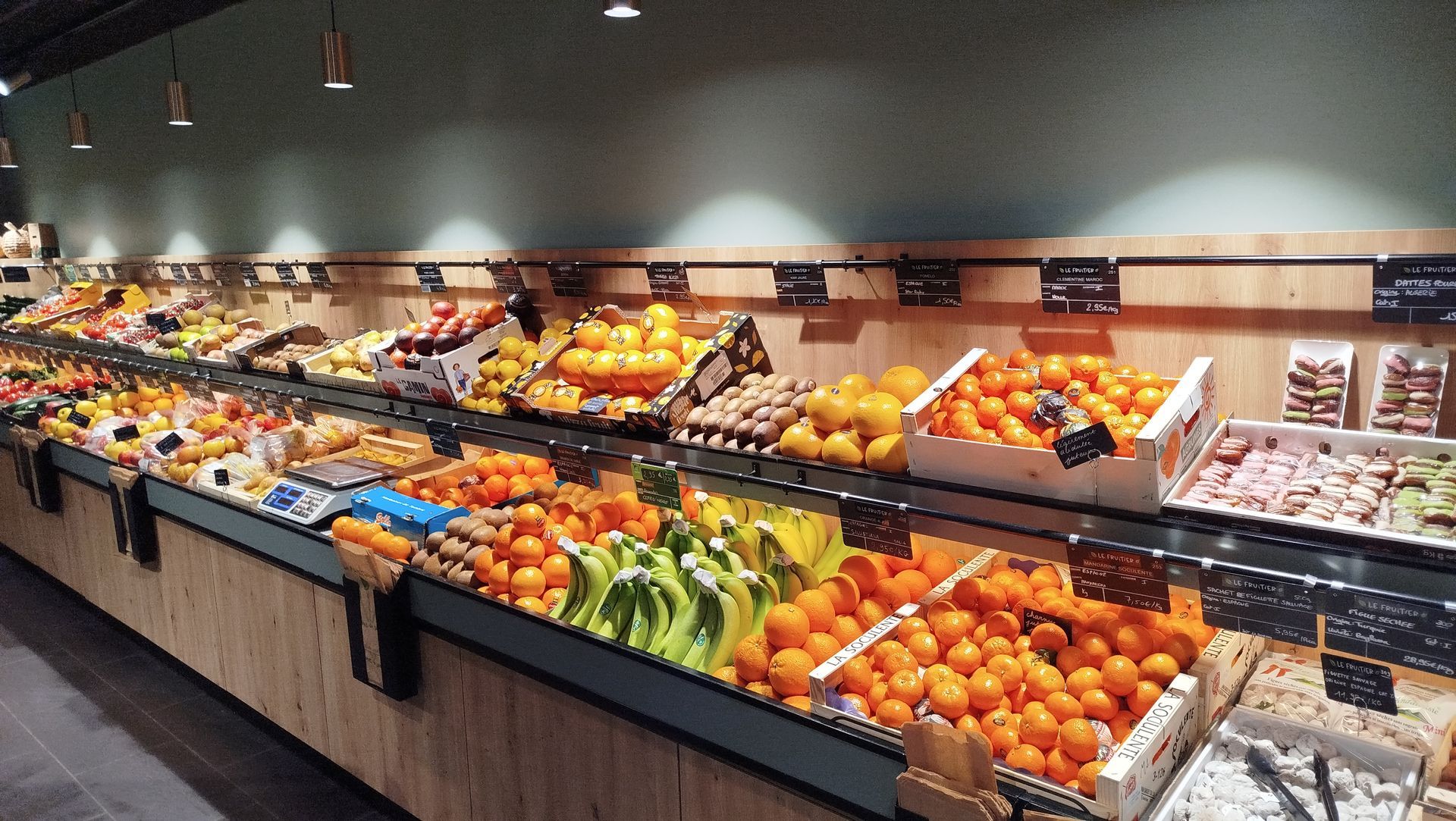 Un étalage de fruits frais sur un marché, notamment des oranges, des oranges sanguines, des citrons et des ananas.