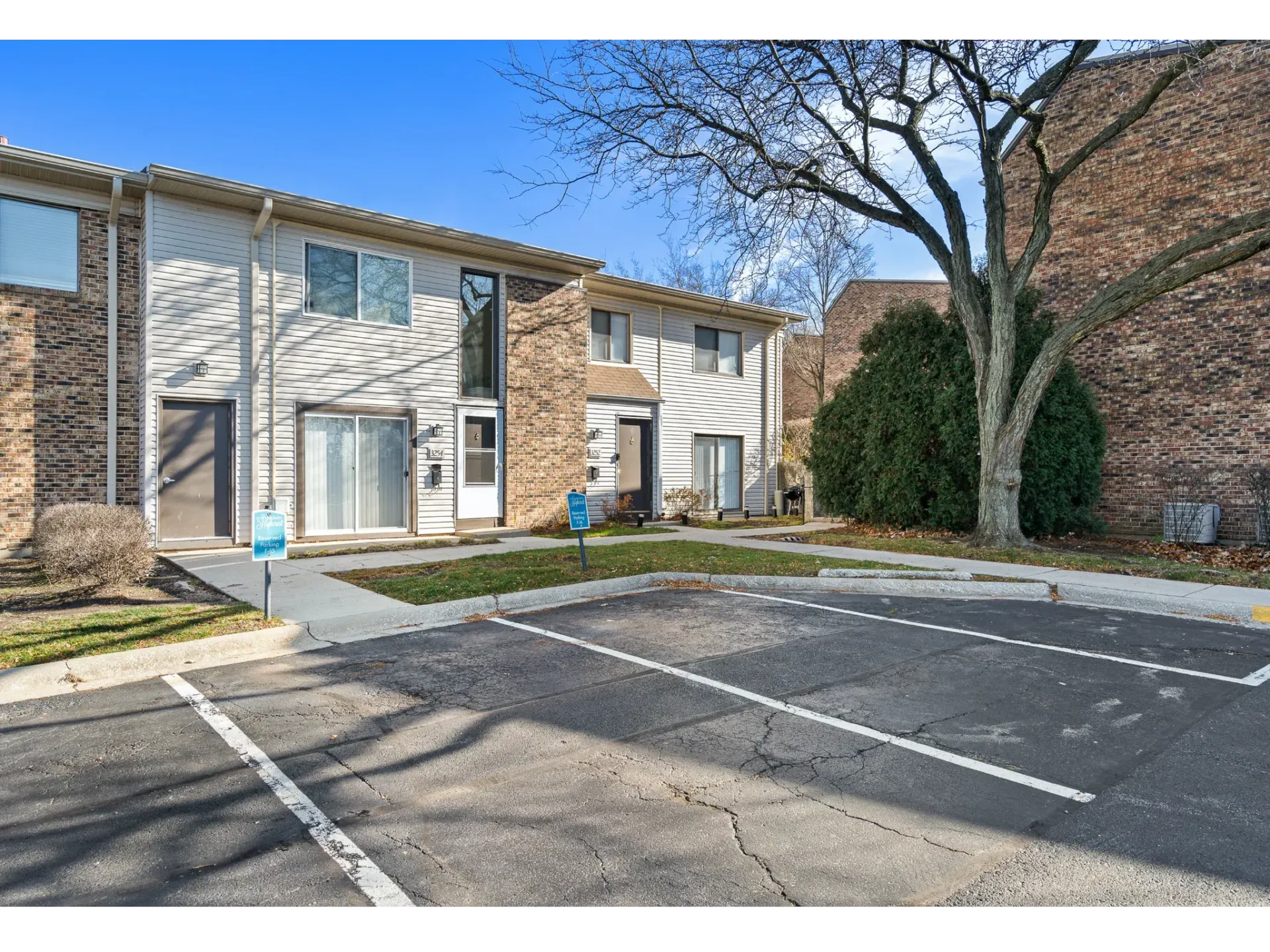Exterior view of a townhouse-style apartment building row with a parking lot.