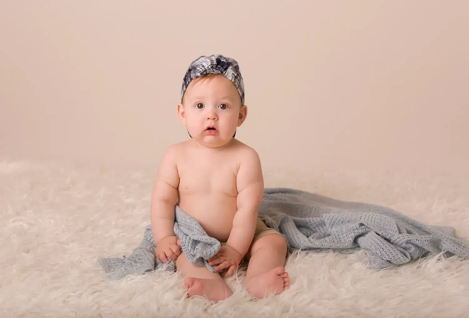 6 month old baby boy photo session. Blue baseball cap, blanket