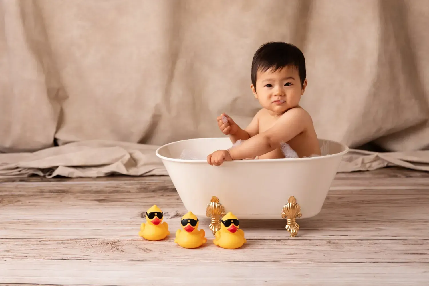 9 month old baby boy in bath tub with bubbles.