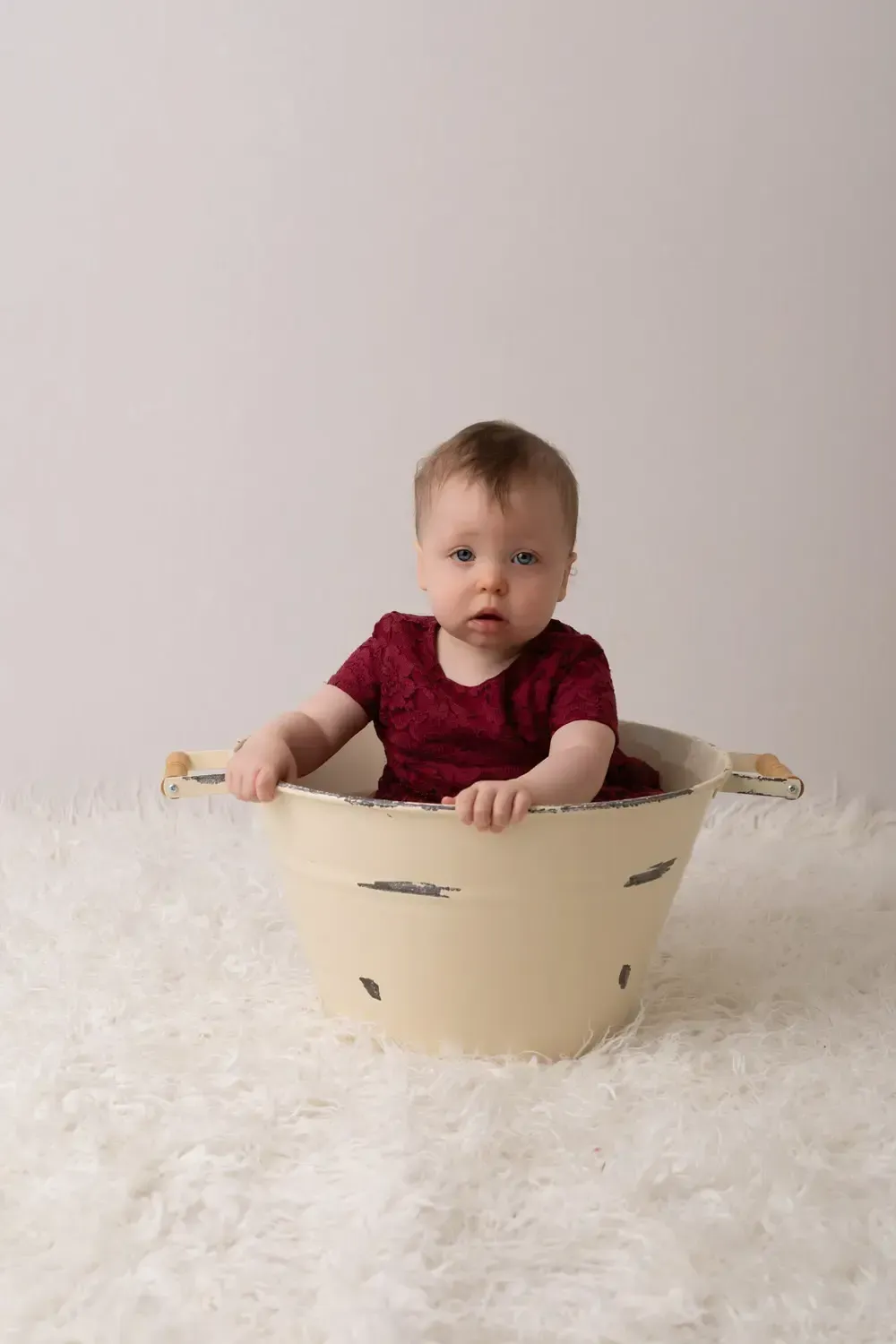 First Birthday baby girl in wine colored lace dress. In bucket