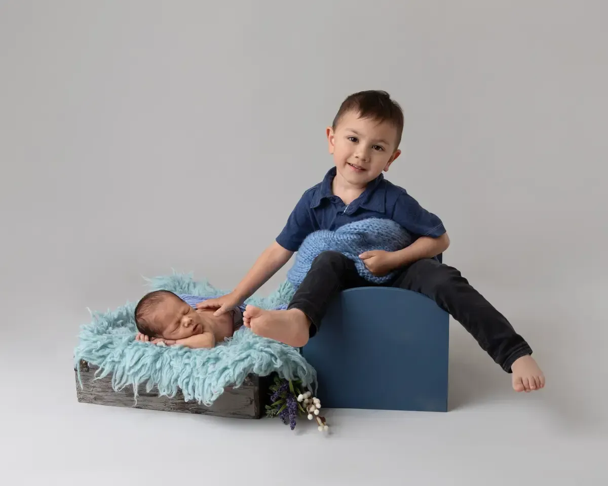 A toddler boy with his newborn brother
