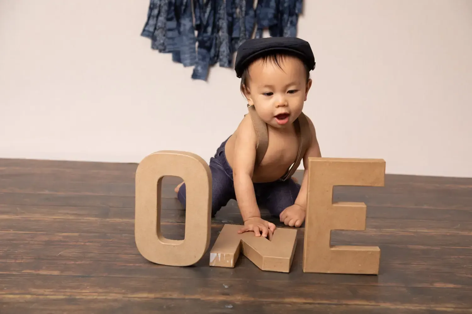 Glendale Asian boy in suspenders and newsboy hat. First Birthday