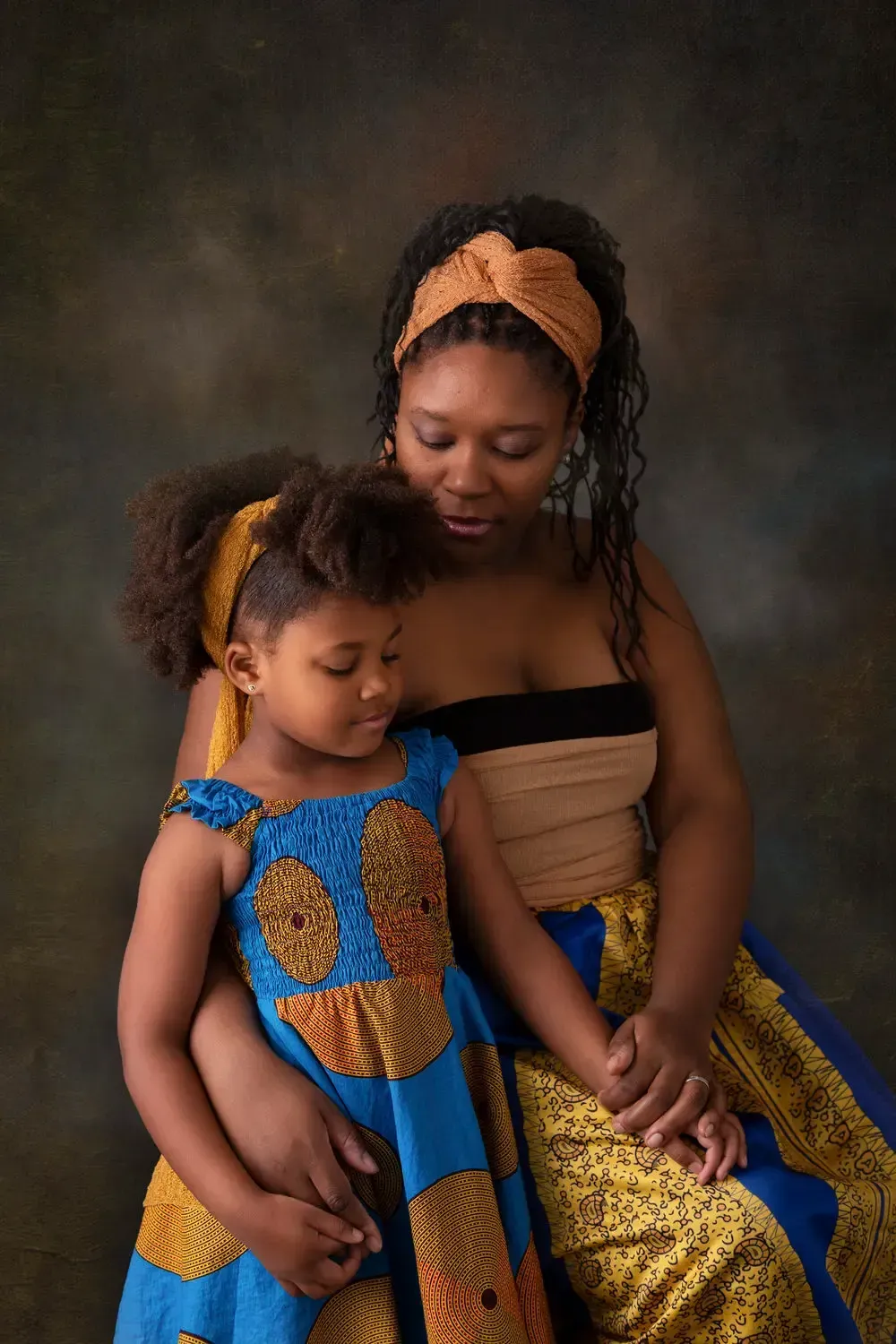 African American mom with 5 year old daughter in ethnic clothing.
