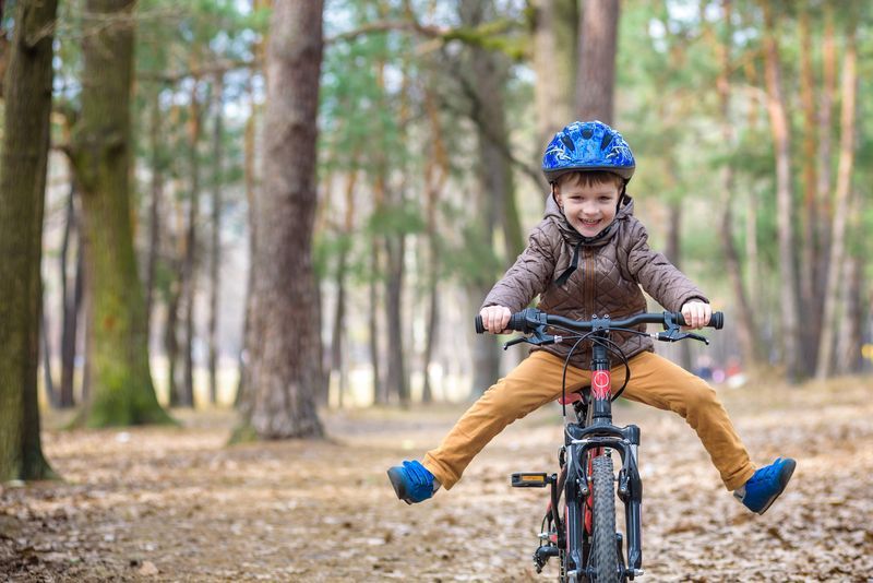 Small boy riding his mountain bike in the forest.