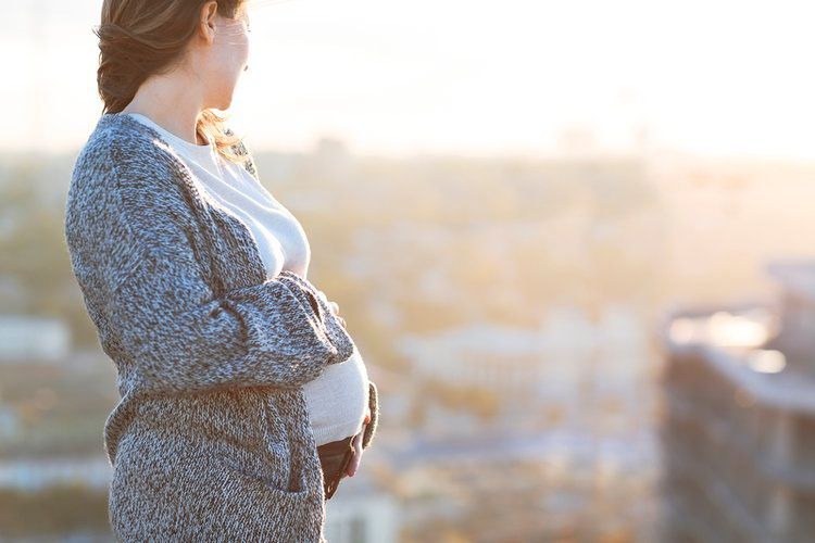 Pregnant Woman Managing Pain looking out the window