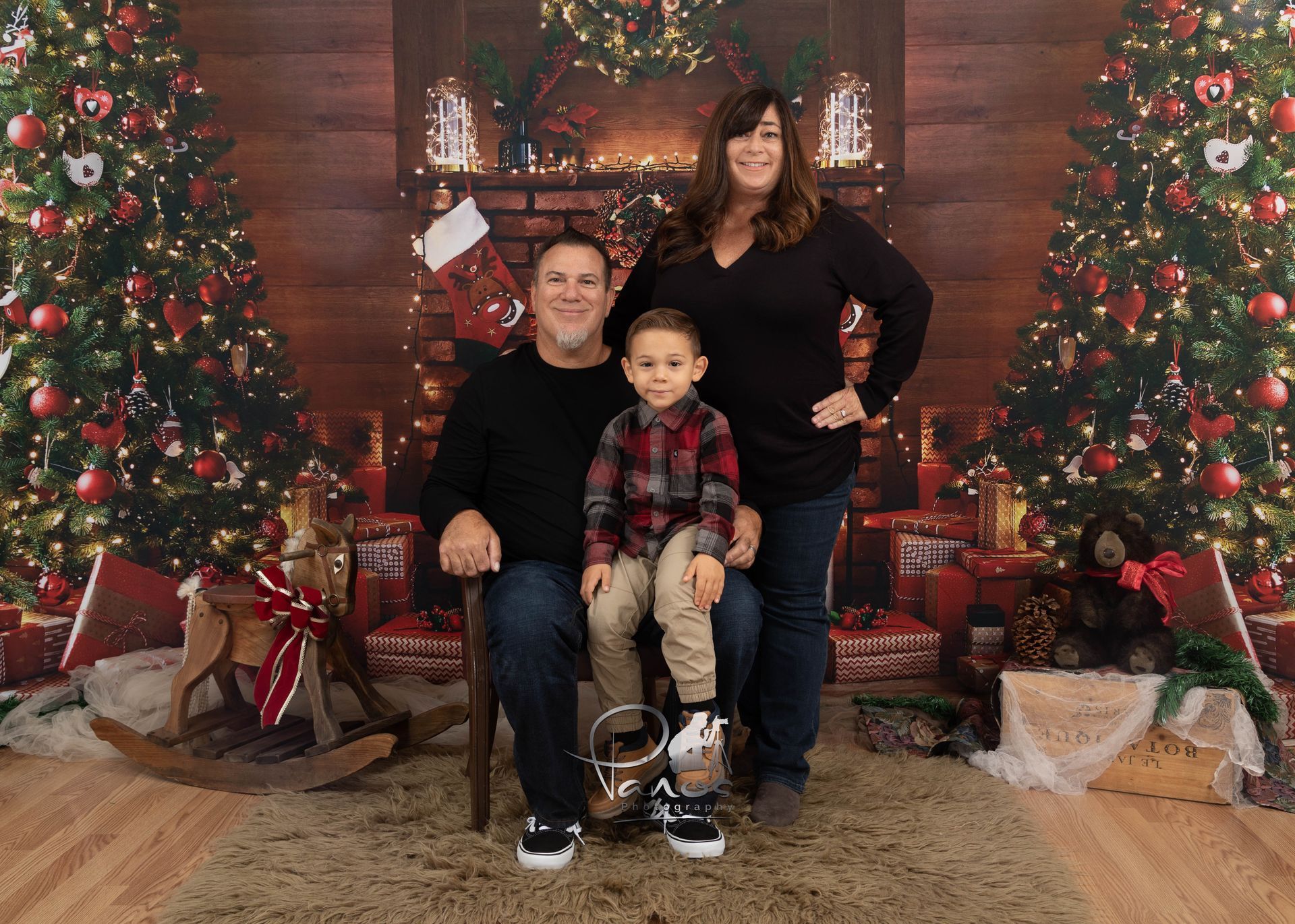 Family portait in front of holiday hearth.