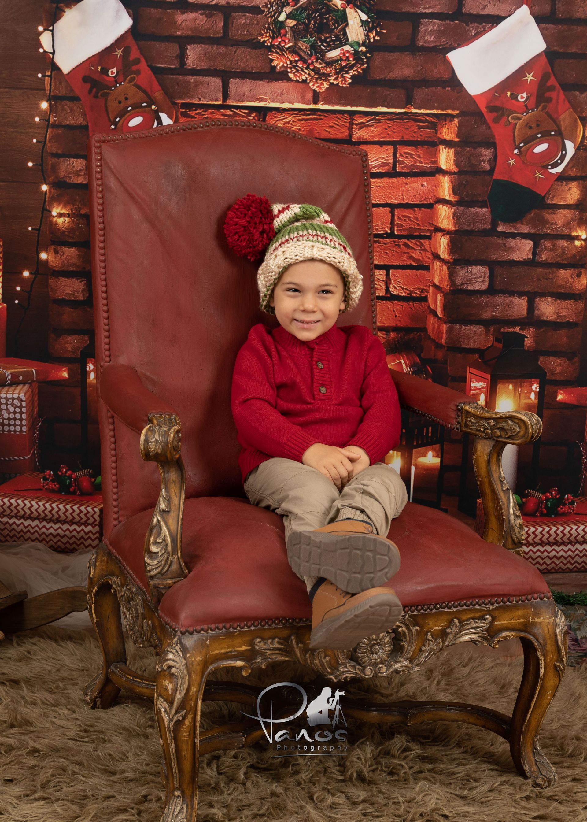 Boy in santa hat in front of fireplace