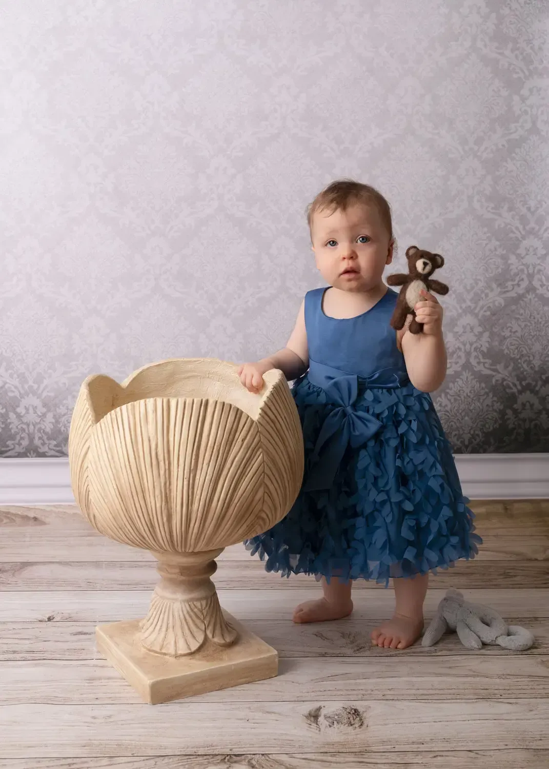 Cake smah for a girt. blue dress. Holding teddy bear