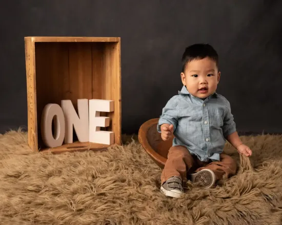 Asiann boy first birthday photohoot. Denish shirt and chino pants. Rustic theme.