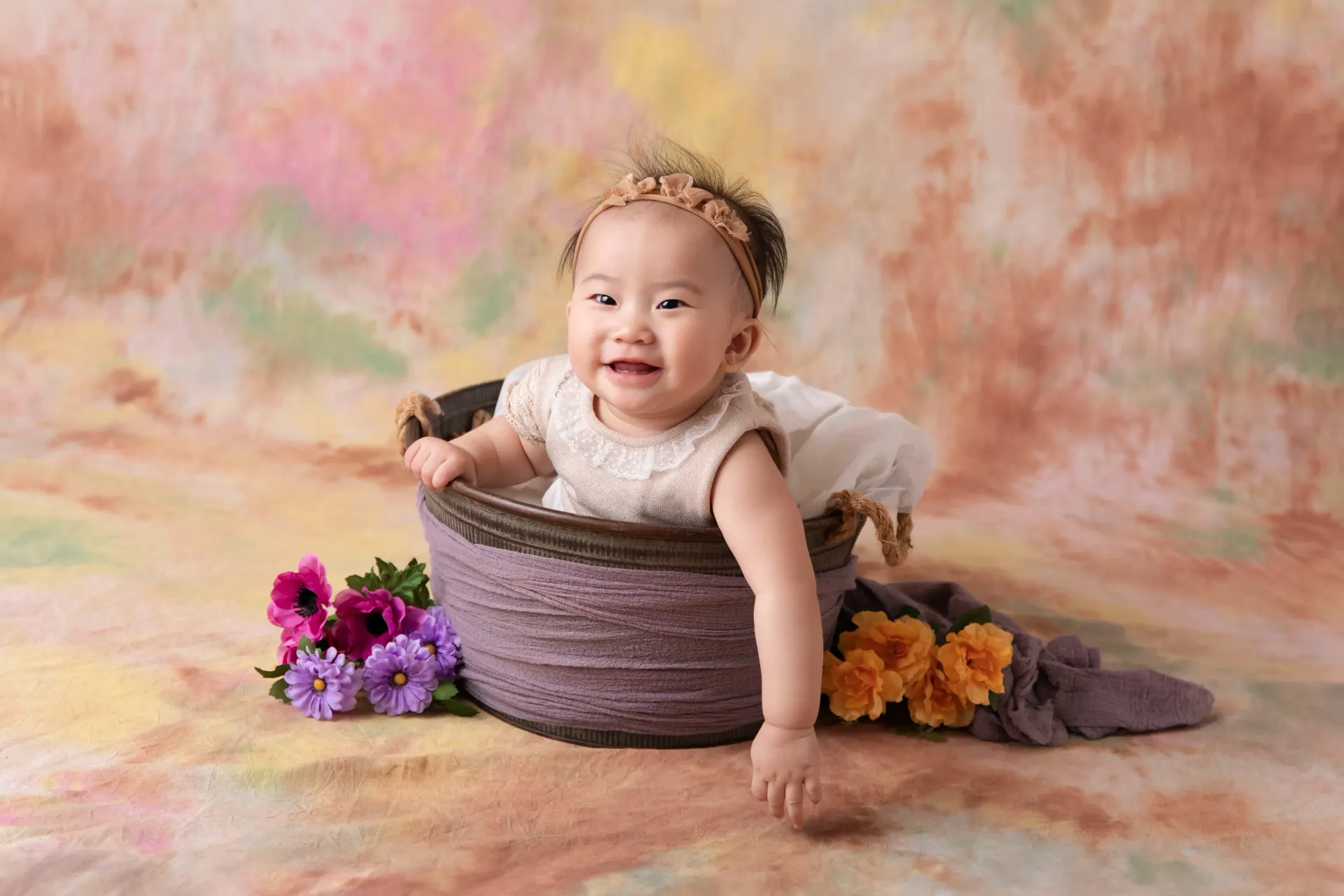 9 Month Old Baby Asian Girl in bucket of flowers laughing