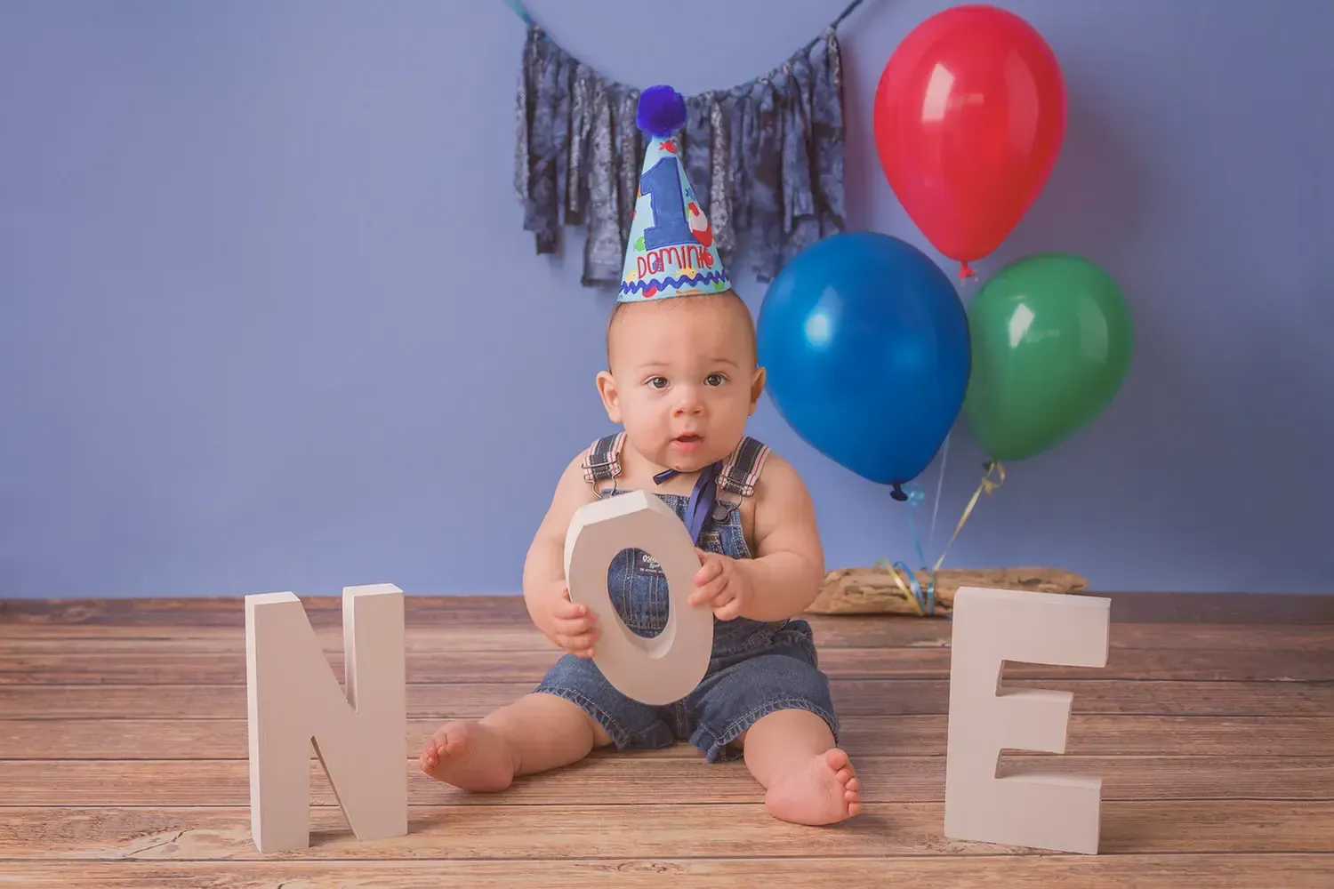 Glendale baby photographer Caucasian boy in overalls with O N E letter.