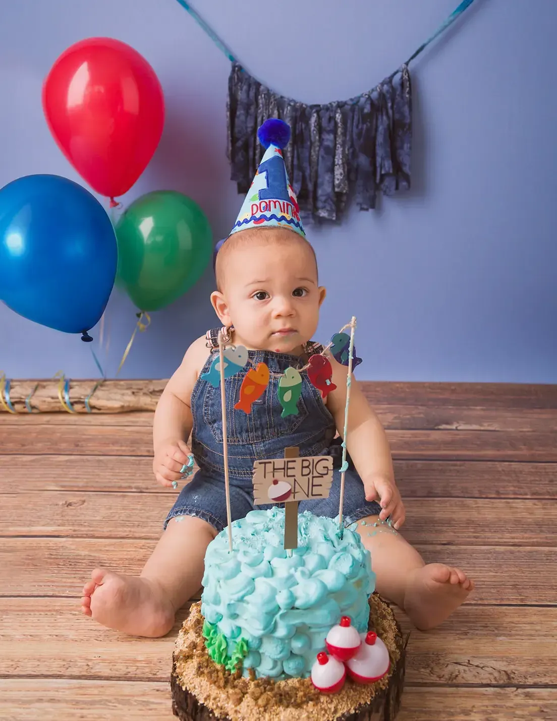 Boy first birthday cake smash Gone Fishing theme. Sitting around blue cake.