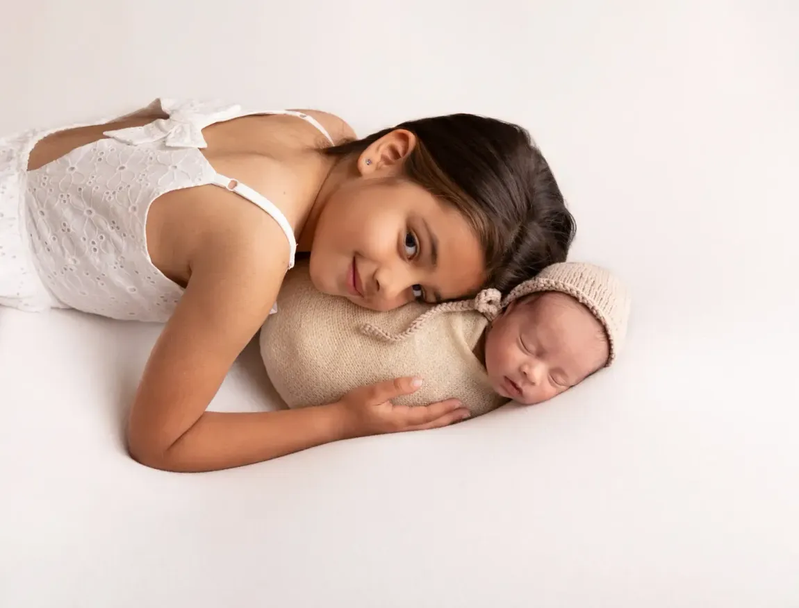 Newborn boy with older sister. Monotone theme white and ecru