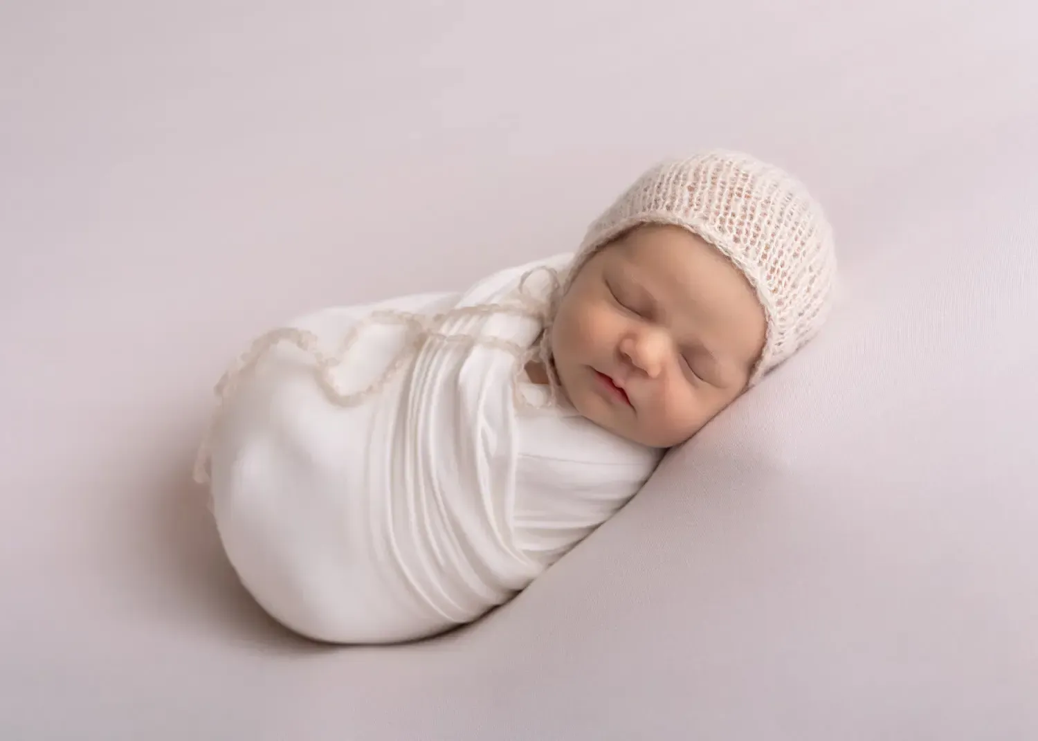 Newborn boy wrapped in white