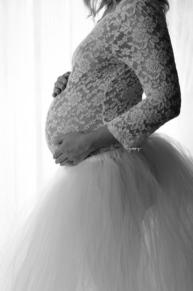 Expecting mom in white lace bodice, profile of baby bump. Black and white
