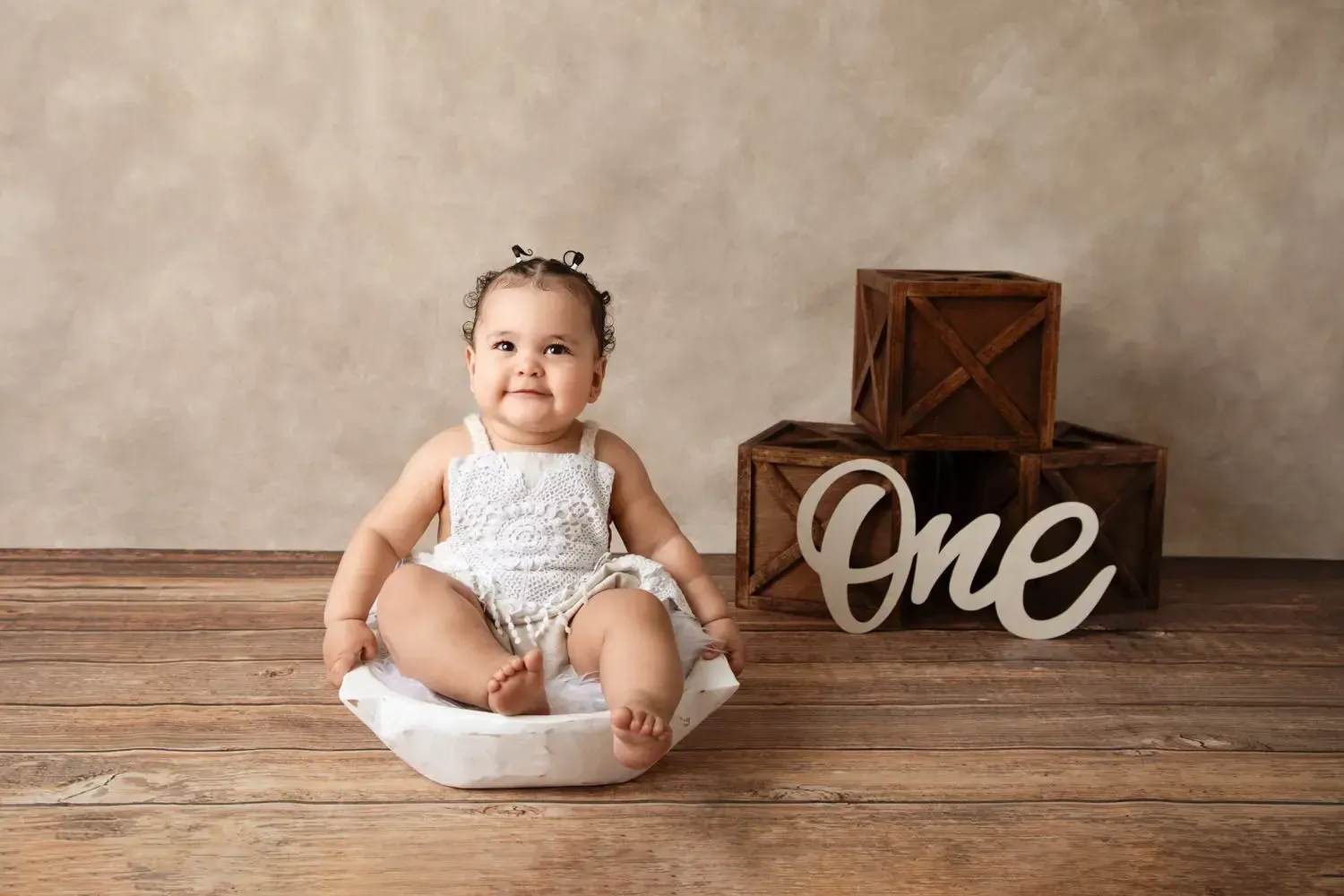 Baby girl sitting in dough bowl for first birthday portraits