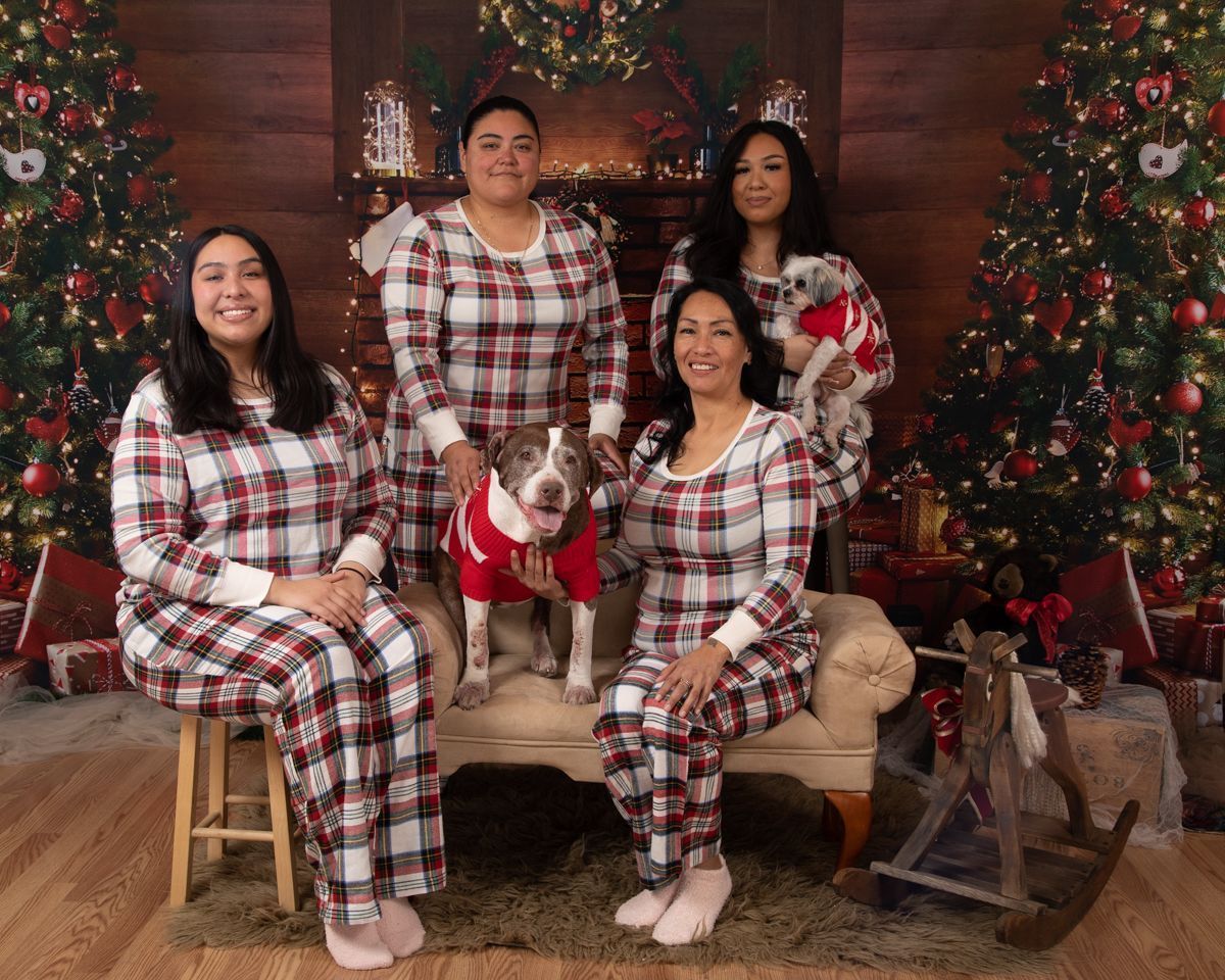 Holiday family in matching PJs in front of fireplace