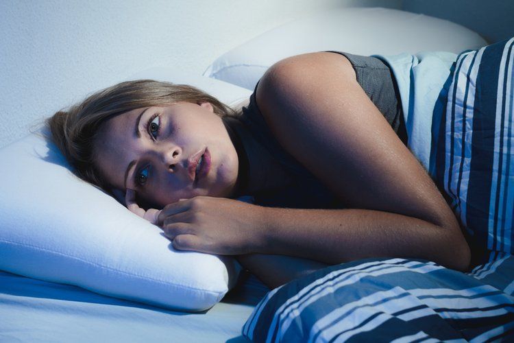 Woman Lying in bed not feeling well