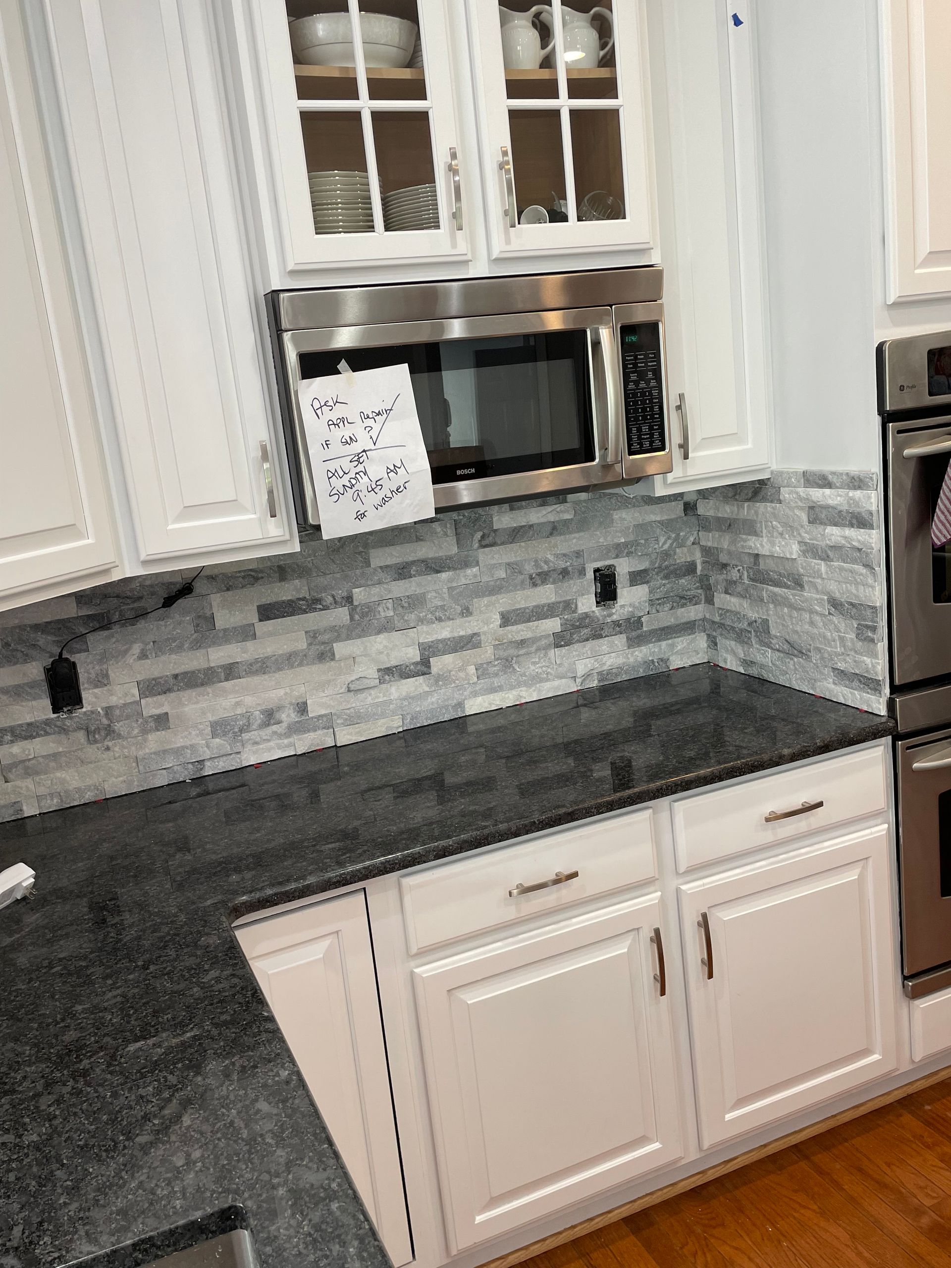 A man is kneeling on the floor applying tile adhesive.
