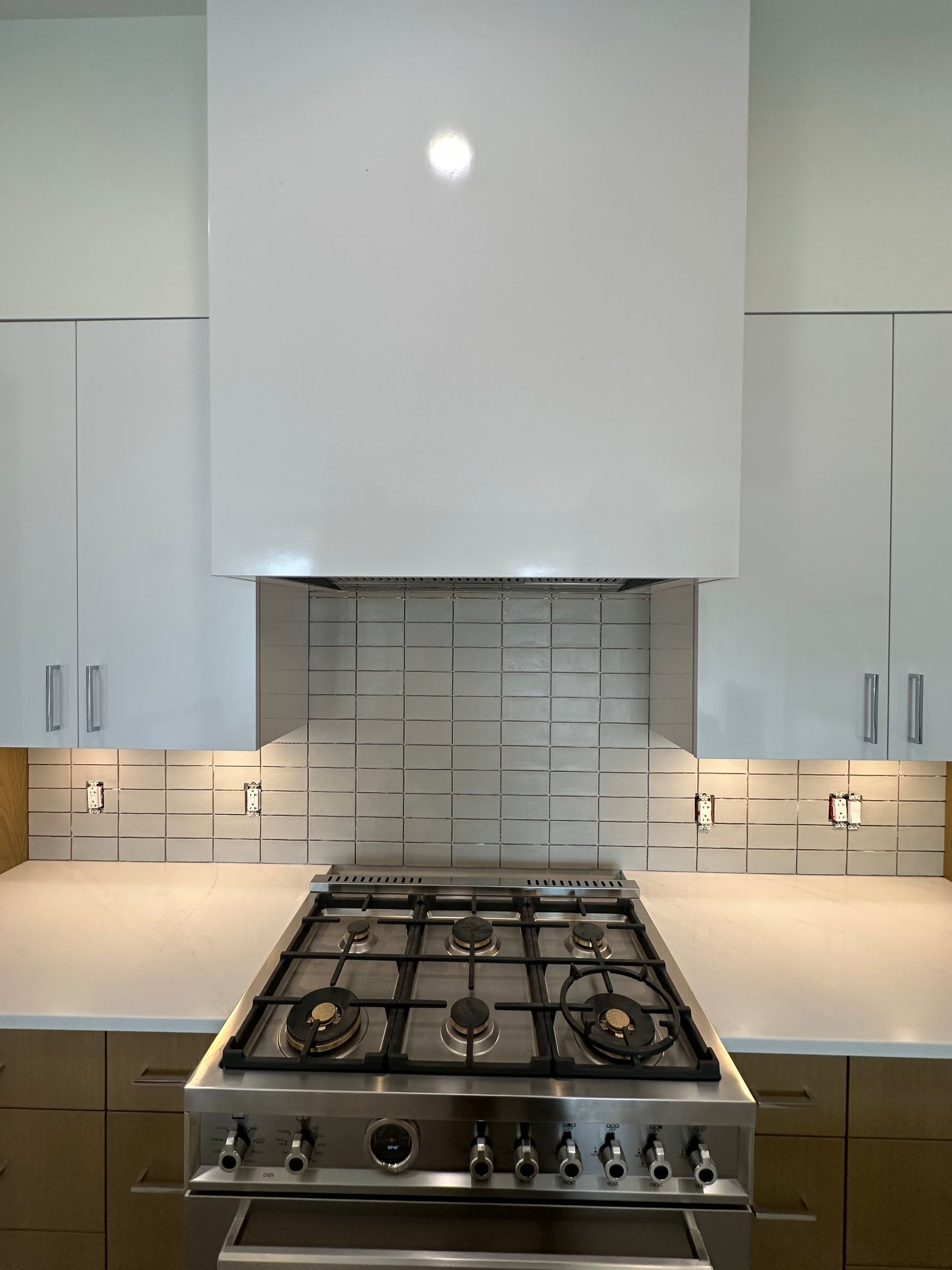A man is laying tiles on the floor in a living room.