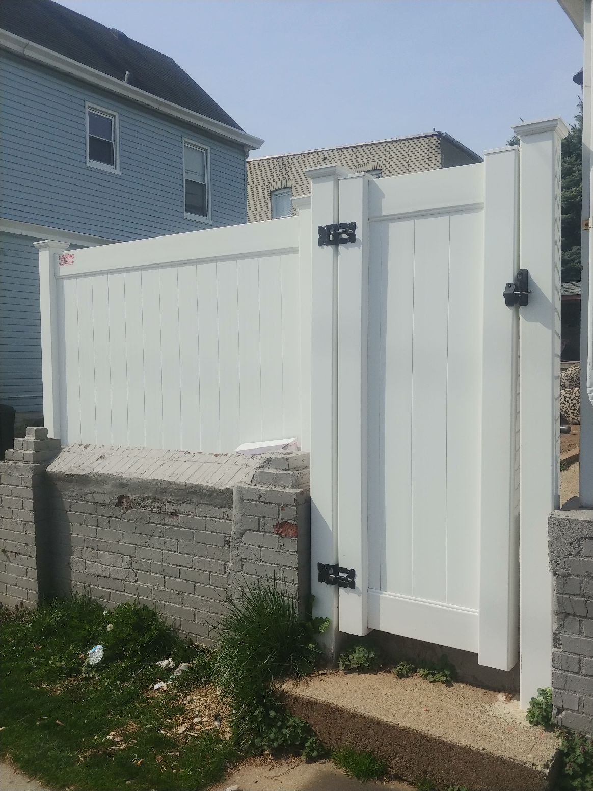 A white fence with a gate in front of a house