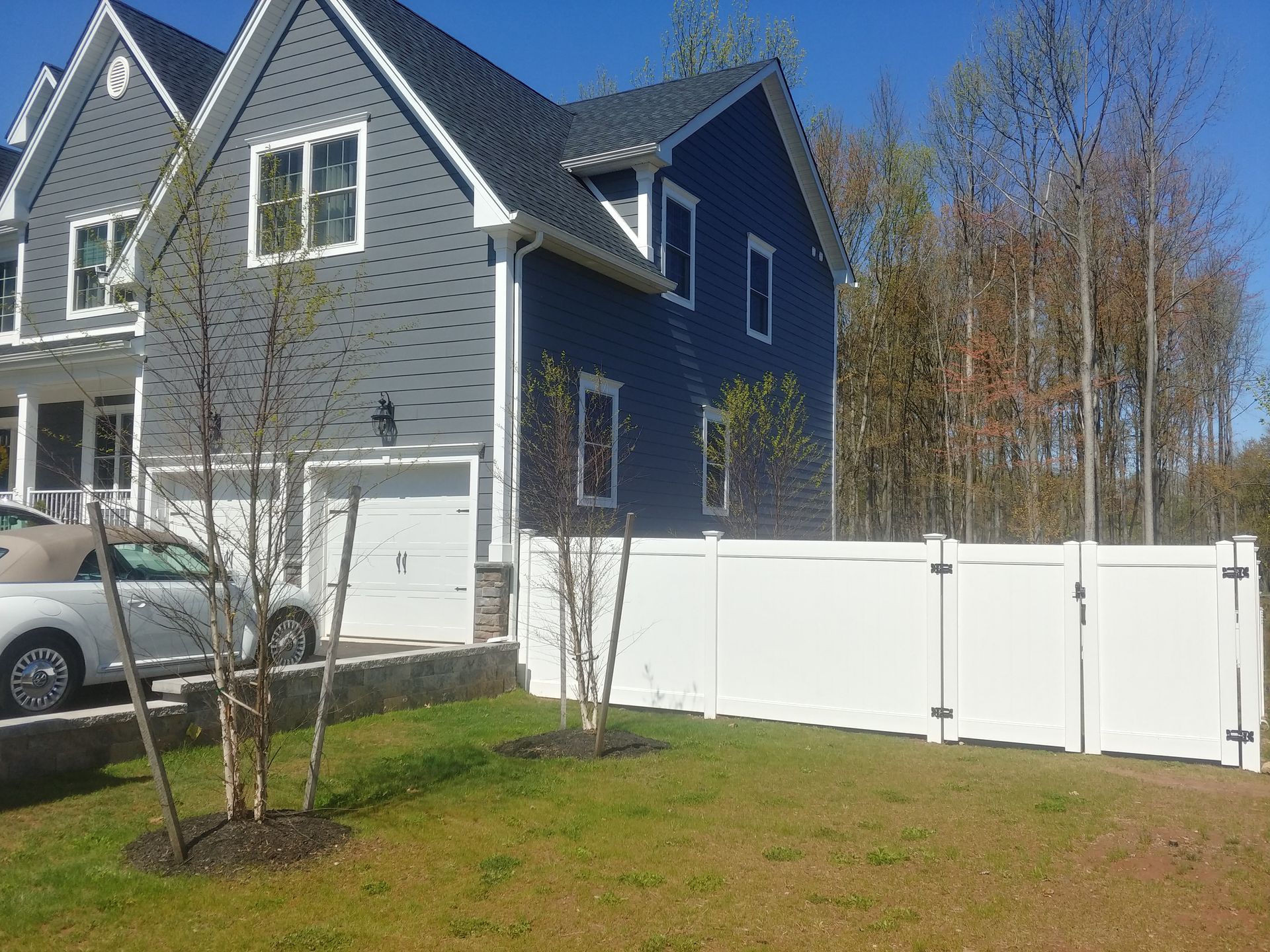 A blue house with a white fence in front of it